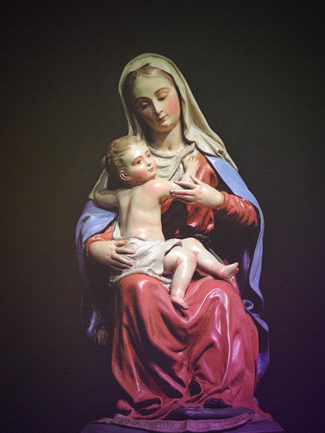 A beautifully crafted statue depicting Mary holding child Jesus, showcasing religious art and devotion.