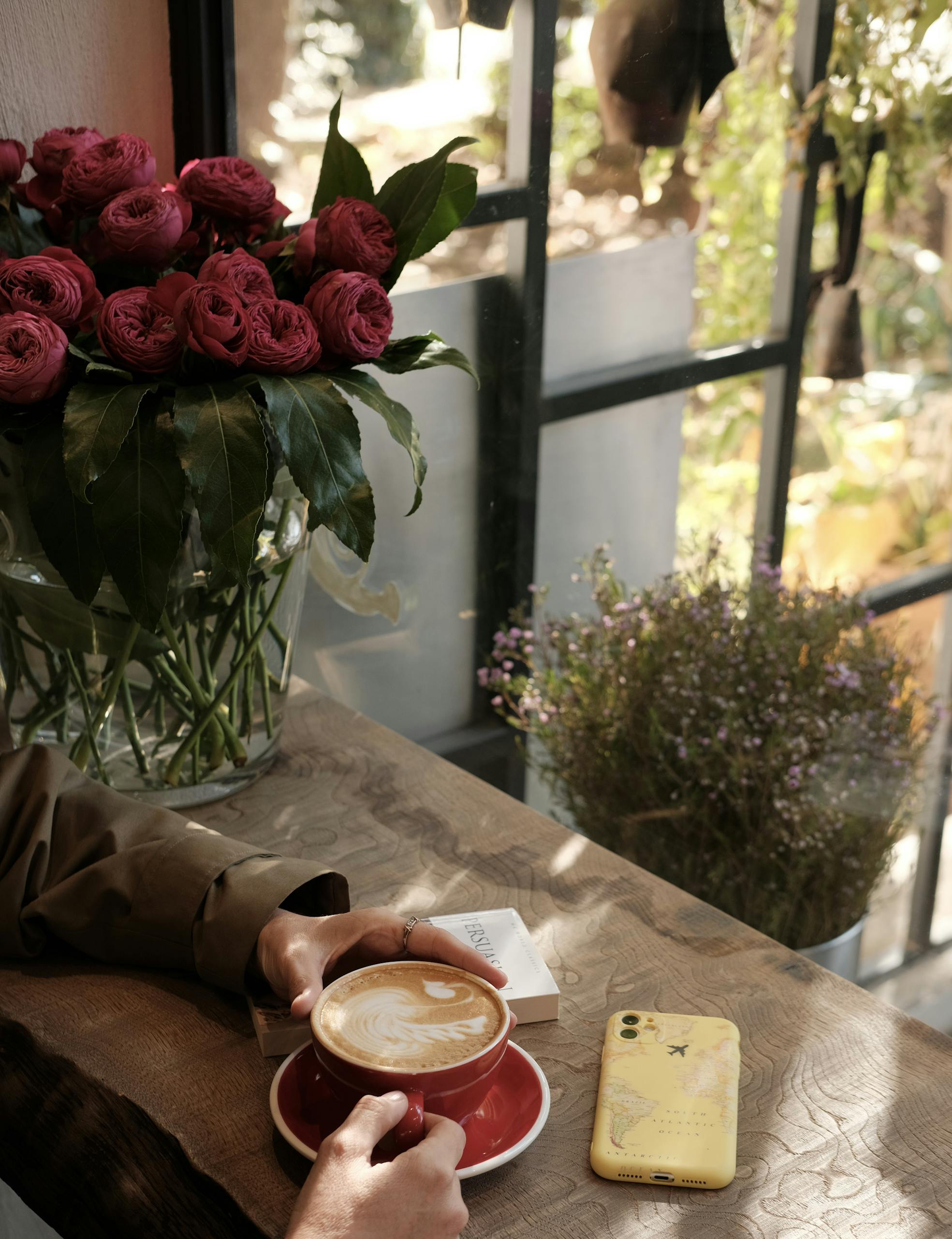 Enjoy a serene coffee moment with latte art in a charming Istanbul café, surrounded by beautiful roses.